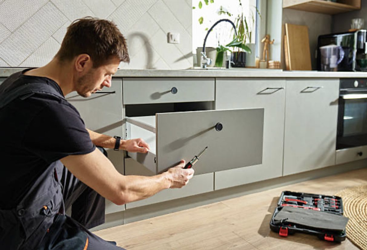 Kitchen fitter adjusting a soft-close drawer