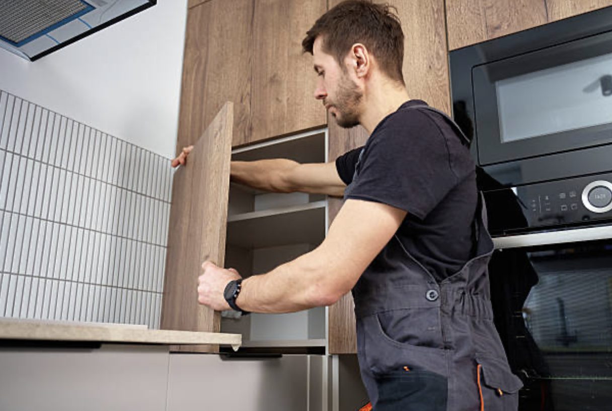 Fitter hanging and aligning a kitchen cabinet door