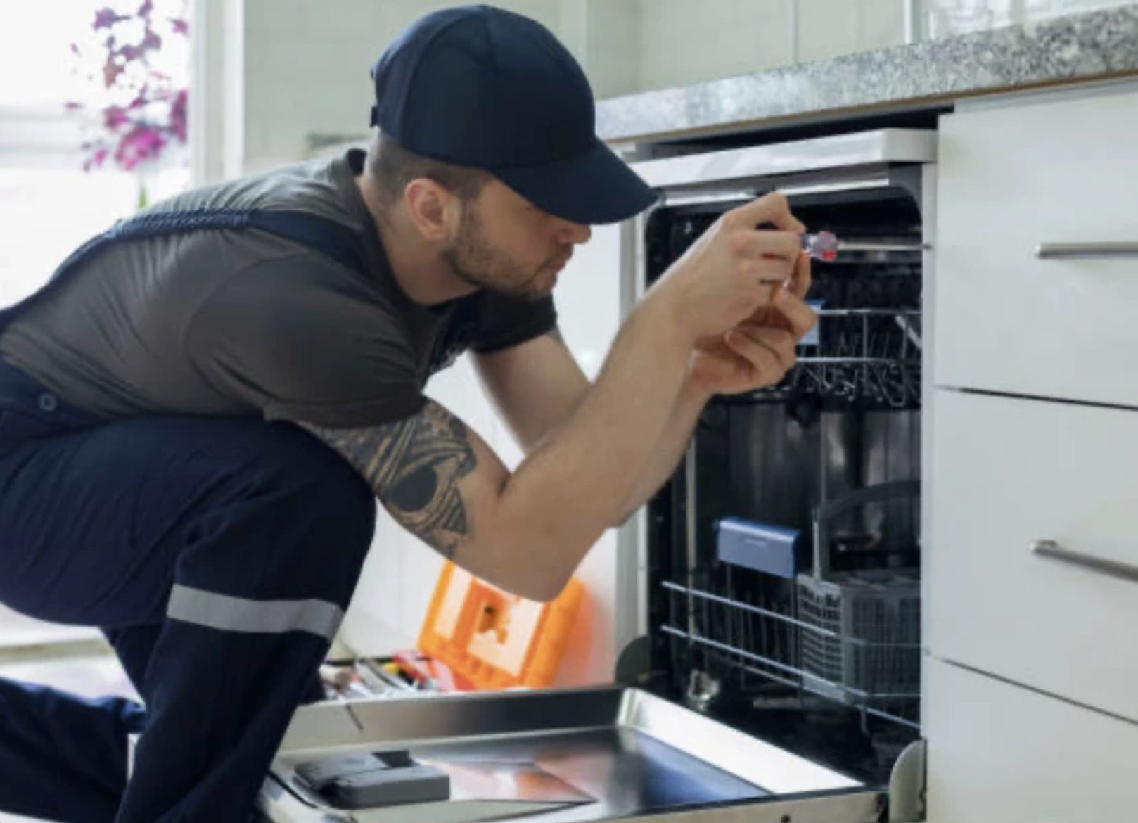 Engineer installing and testing a dishwasher in an IKEA kitchen