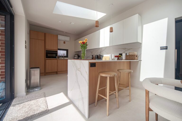 Oak kitchen with white wall units and marble-effect island with breakfast bar
