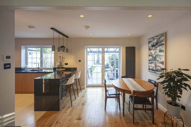 Open-plan kitchen with dark island, pendant lights and oak floor