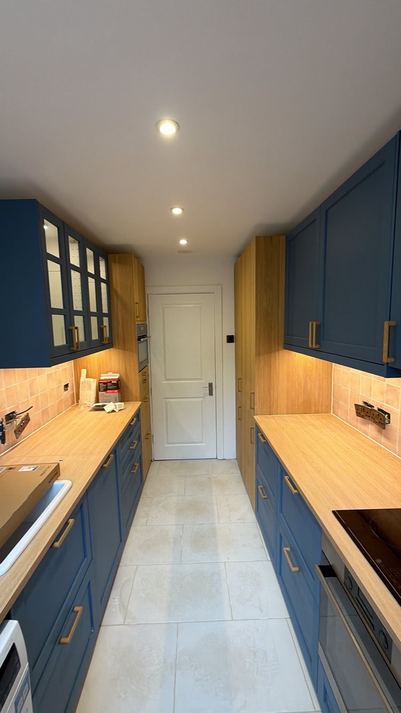 Navy IKEA galley kitchen with oak worktops and brass handles, Battersea London